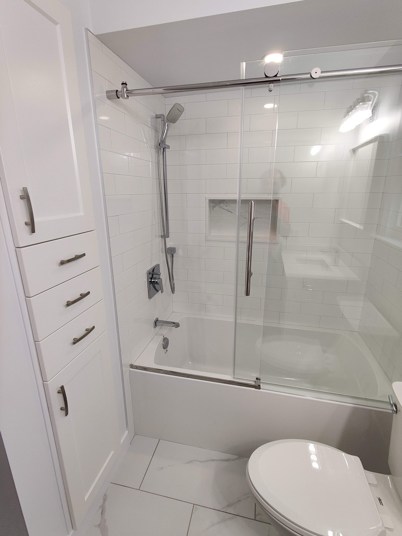 Bathroom with a glass shower screen over a white tub
