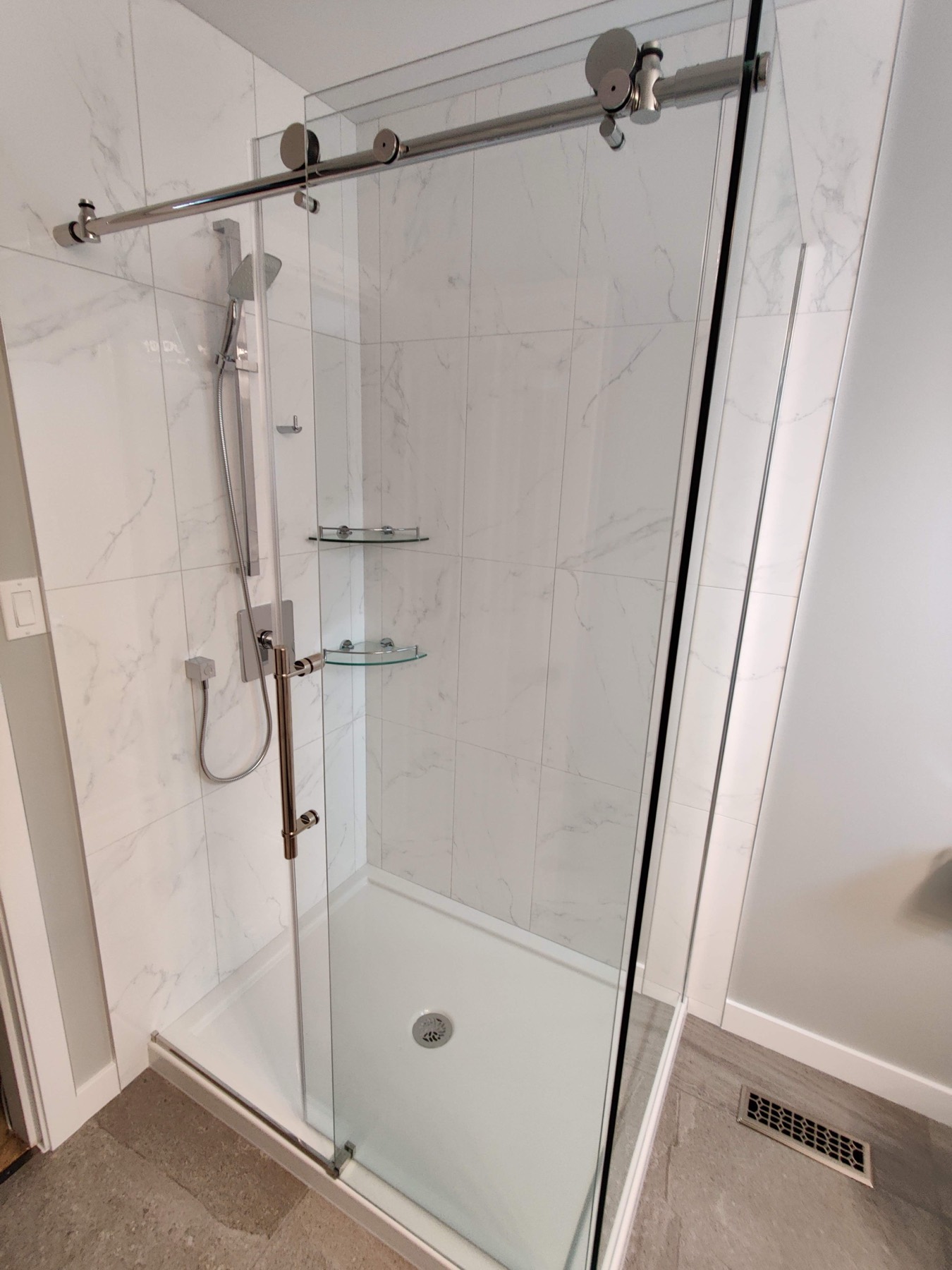 Sliding glass shower door on a tiled shower enclosure