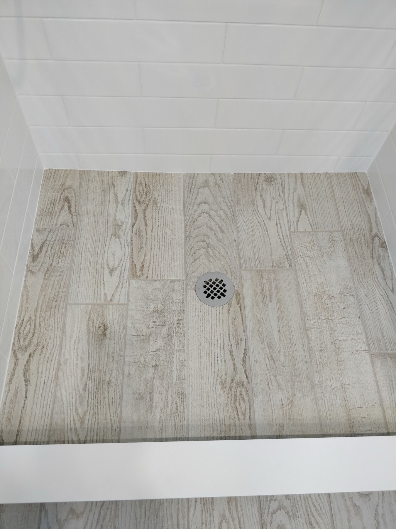 Tiled shower floor meeting the wall at a clean line