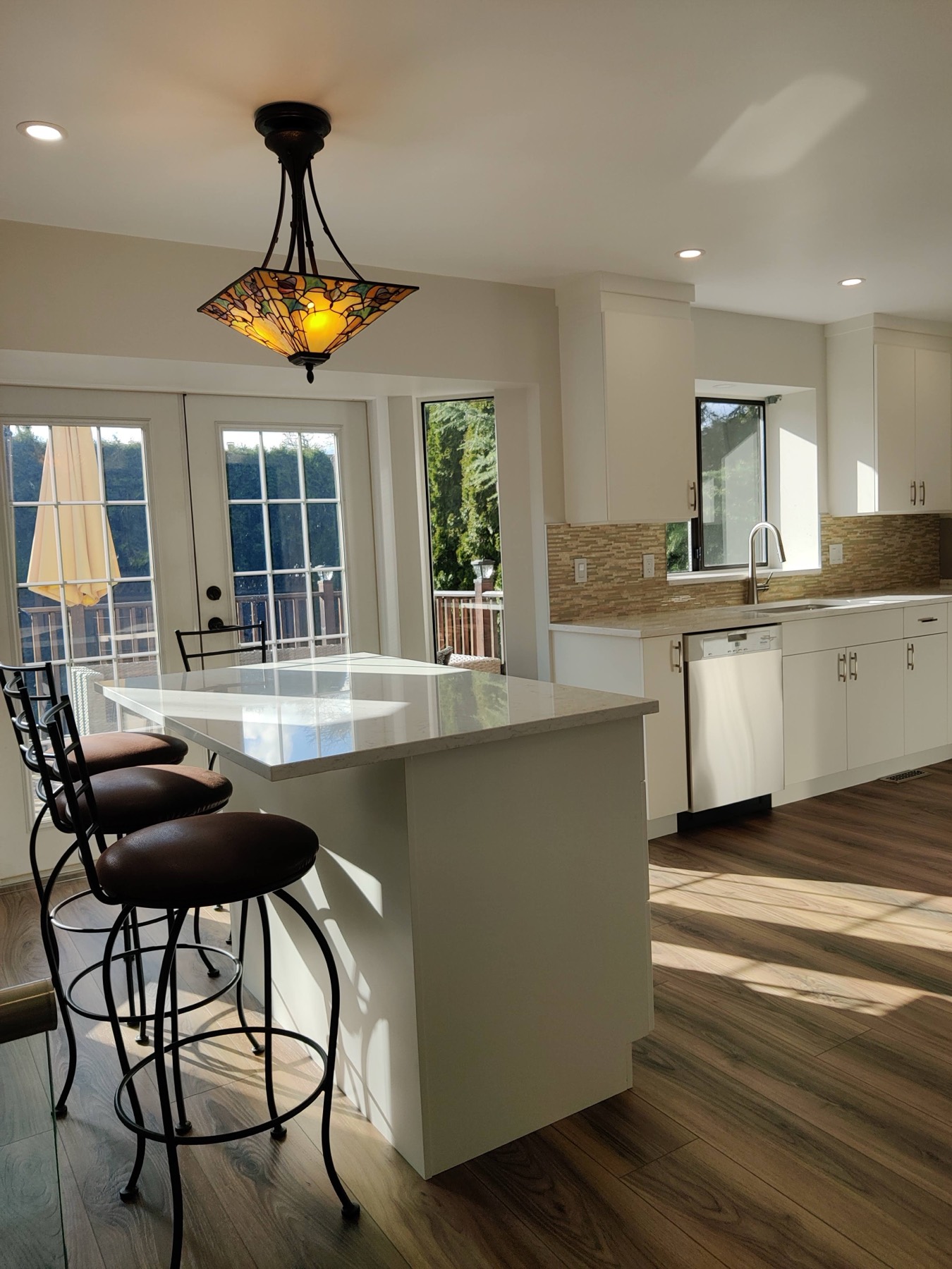 Open kitchen with an island, pendant light and pale flooring