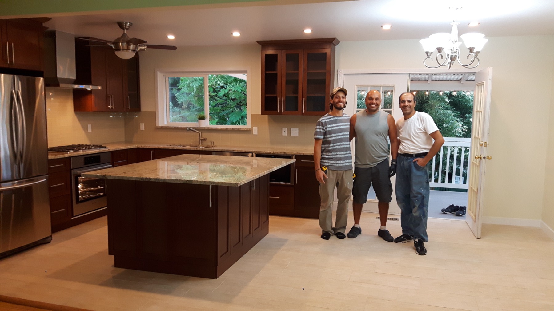 Sharam and two colleagues standing in a kitchen they finished
