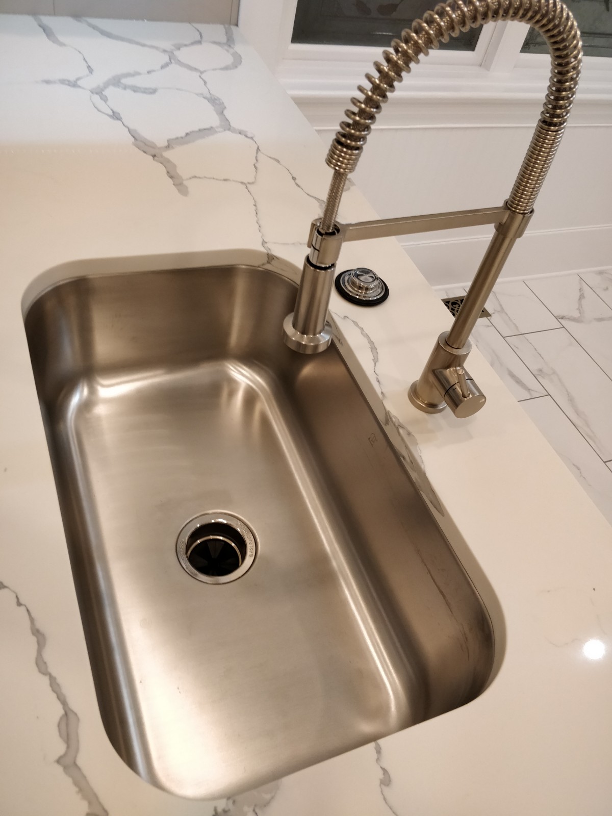Undermount sink with a pull down spring faucet in stone